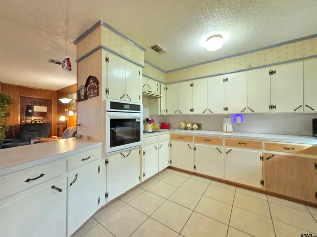 a kitchen with granite countertop cabinets a sink a stove and a window