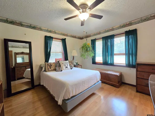 a bedroom with a large bed and a chandelier fan