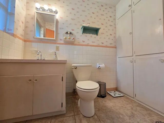 a bathroom with a toilet sink and mirror