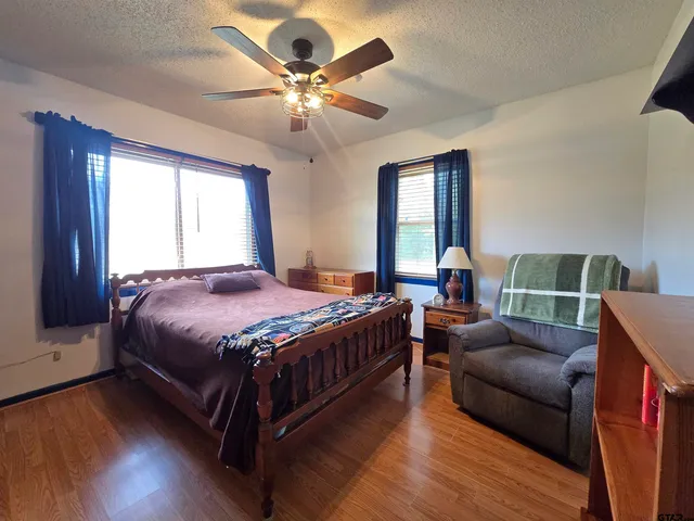 a spacious bedroom with a bed a chandelier and a couch