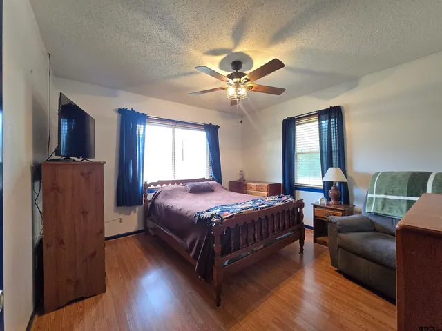 a bedroom with a bed couch and a window