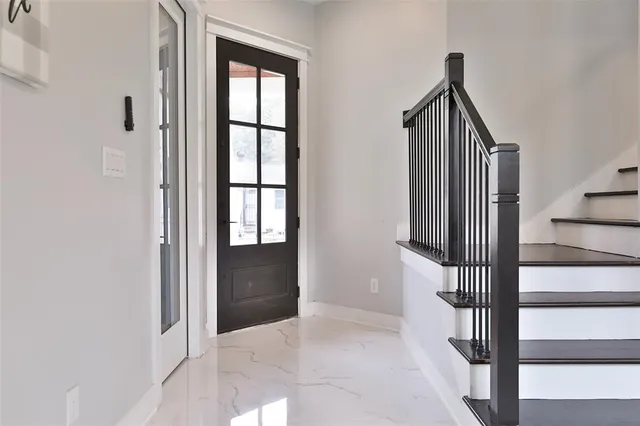 a view of hallway with stairs and a wooden floor