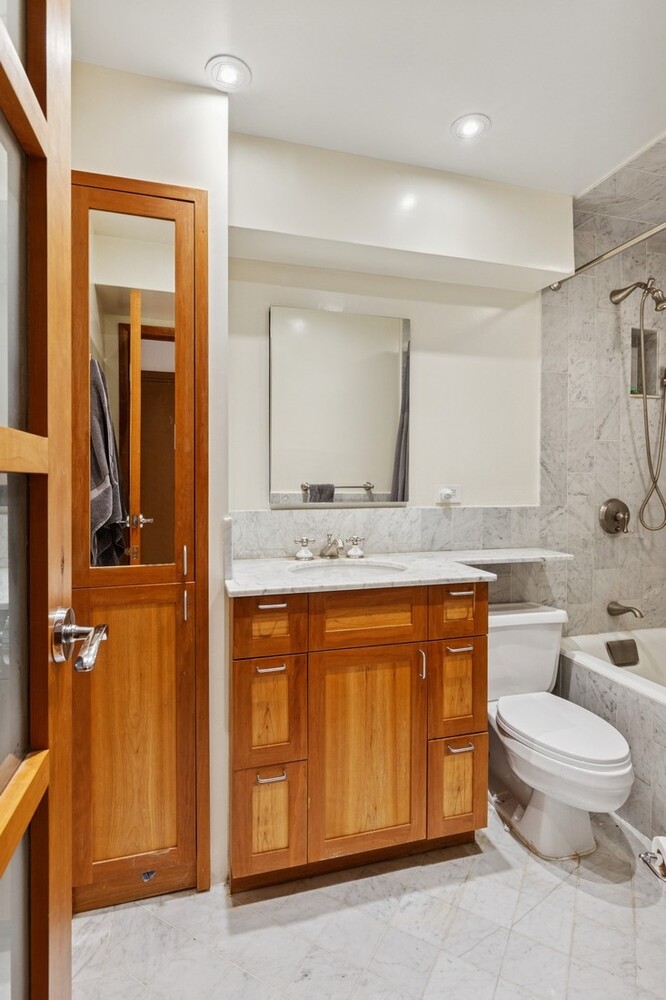 253 West 73rd Street, Unit 5O Manhattan, NY 10023 - Photo 10 of 11 a spacious bathroom with a granite countertop sink and a mirror