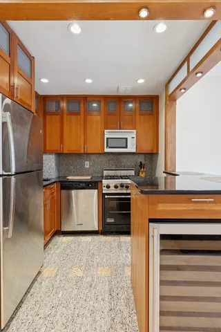 a kitchen with stainless steel appliances granite countertop a stove a sink and a refrigerator