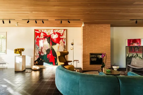 a living room with fireplace furniture and a large window