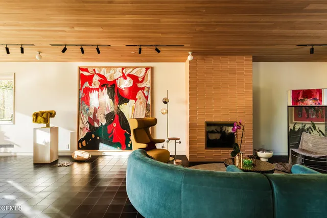 a living room with fireplace furniture and a large window