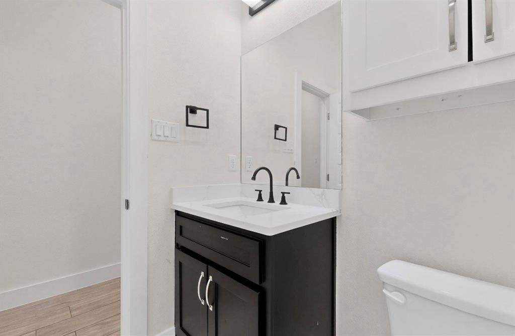 339 Cross Tie Ranch Road Trinidad, TX 75163 - Photo 22 of 29 Modern vanity featuring a dark wood-finish cabinet with silver hardware, a white countertop, and a contemporary black faucet