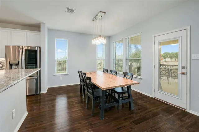 a large kitchen with stainless steel appliances granite countertop a lot of counter space and wooden floor