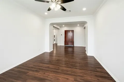 a dining room with wooden floor and chandelier