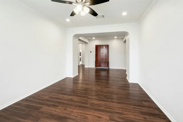 a dining room with wooden floor and chandelier