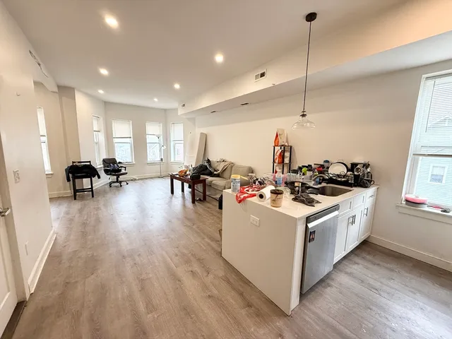 a kitchen with a stove and a wooden floor