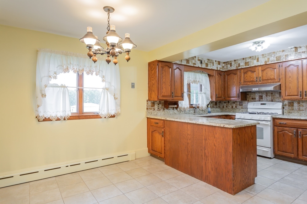 141 Kaufman Road Somerset, MA 02726 - Photo 11 of 26 a kitchen with stainless steel appliances granite countertop a refrigerator a sink dishwasher a stove with wooden cabinets and floor