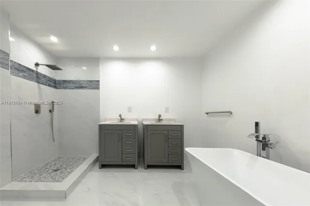 a bathroom with a tub a sink and mirror