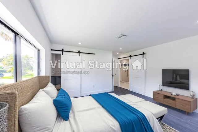 a bedroom with a large bed and a flat screen tv