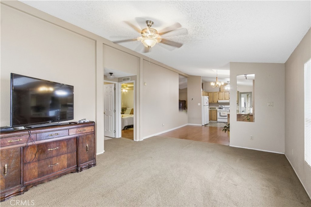 7156 North Winton Way Winton, CA 95388 - Photo 10 of 27 a view of an empty room with a flat screen tv and kitchen view