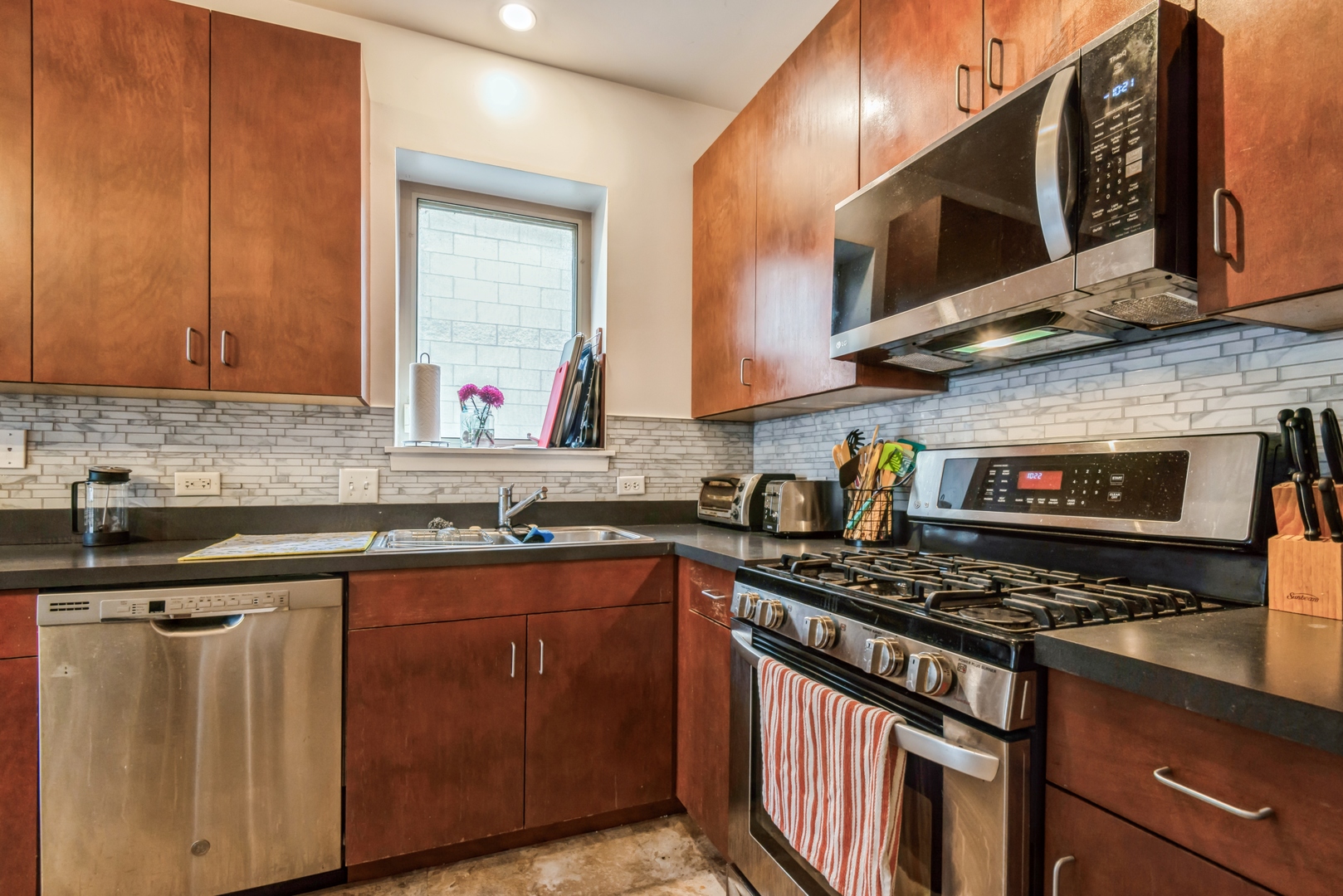 1022 South Racine Avenue, Unit 201 Chicago, IL 60607 - Photo 3 of 13 a kitchen with stainless steel appliances a sink stove and microwave