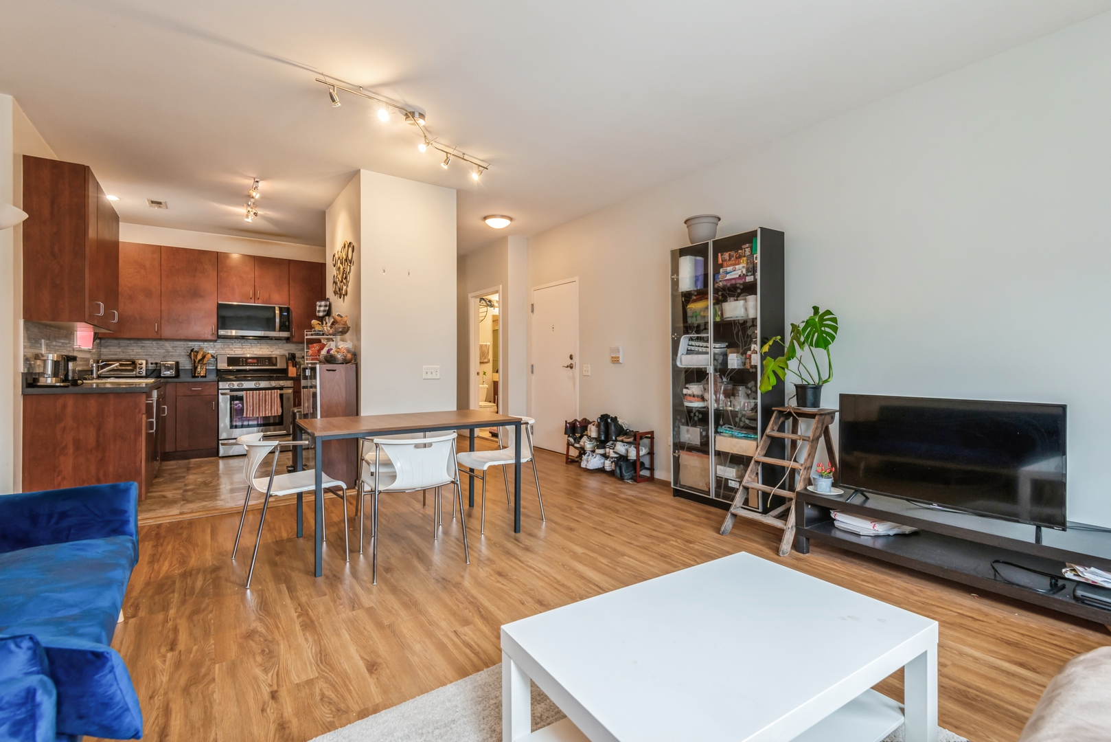 1022 South Racine Avenue, Unit 201 Chicago, IL 60607 - Photo 6 of 13 a living room with furniture a flat screen tv and kitchen view
