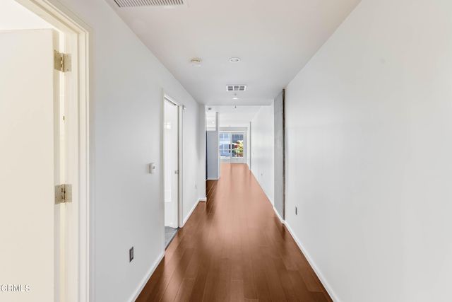a view of a hallway with wooden floor