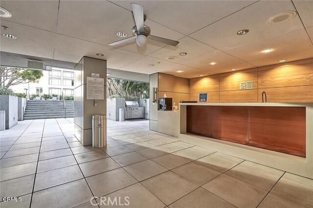 a view of a patio with couches table and chairs under an umbrella