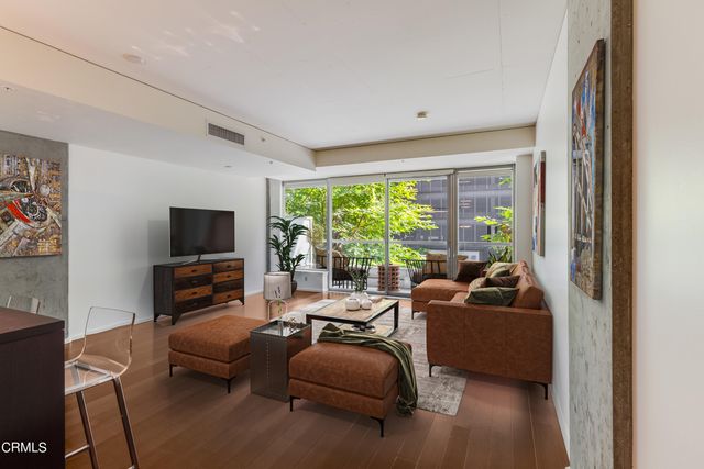 a living room with furniture a flat screen tv and a large window