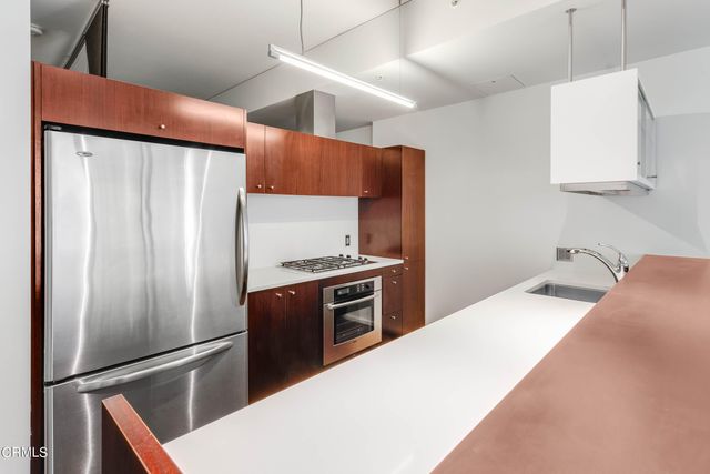 a kitchen with stainless steel appliances a refrigerator and a stove top oven