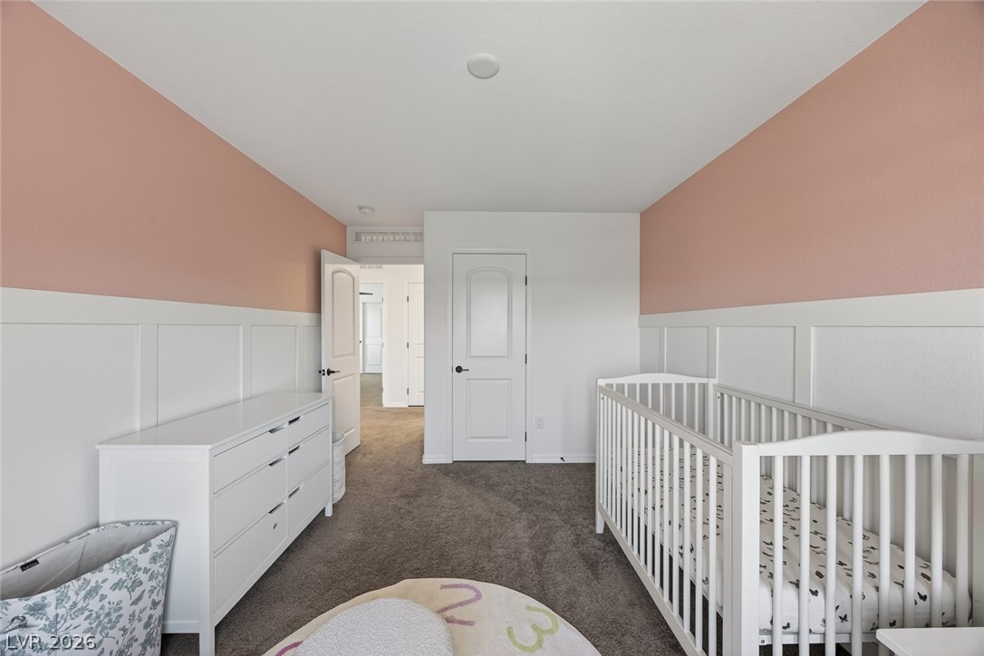 10446 Emerald Rye Street Las Vegas, NV 89183 - Photo 26 of 37 A well-lit room with soft pink and white paneled walls, offering a peaceful and charming atmosphere.