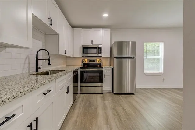a kitchen with stainless steel appliances a refrigerator sink and microwave