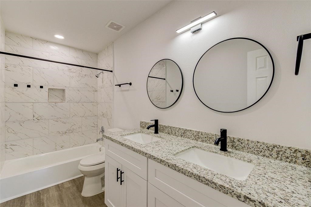 4218 Friar Point Road Houston, TX 77047 - Photo 21 of 26 a bathroom with a toilet a sink and a mirror