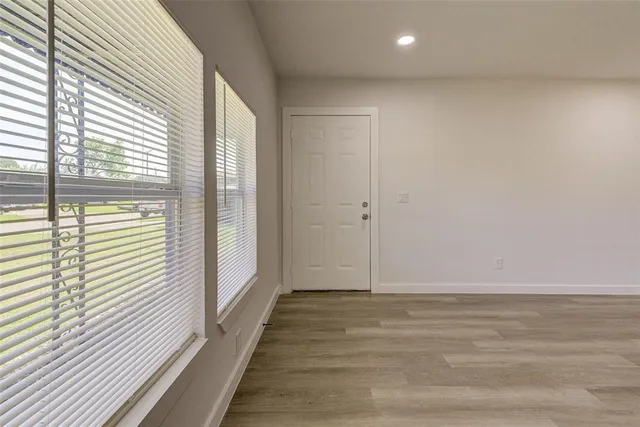 a view of a room with wooden floor and a window