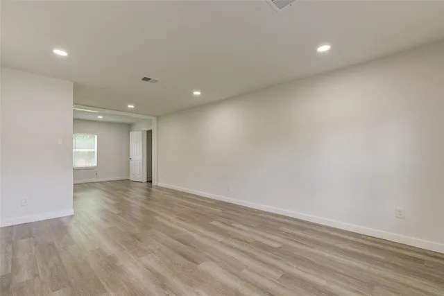 a view of an empty room with wooden floor
