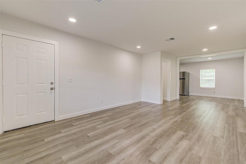 4218 Friar Point Road Houston, TX 77047 - Photo 6 of 26 an empty room with wooden floor and window