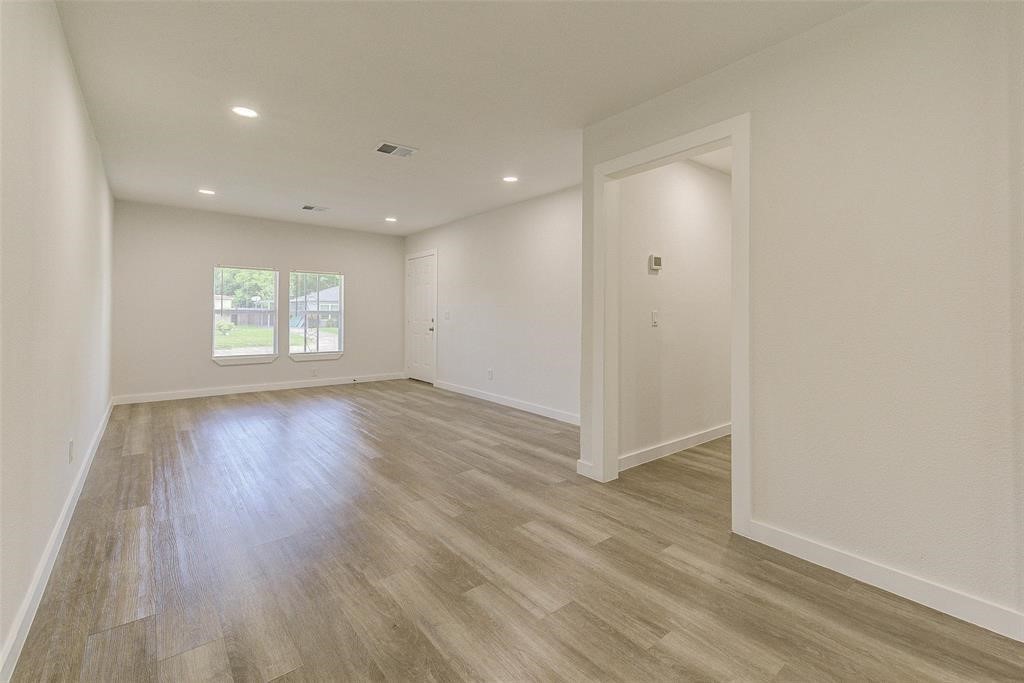 4218 Friar Point Road Houston, TX 77047 - Photo 9 of 26 an empty room with wooden floor and window
