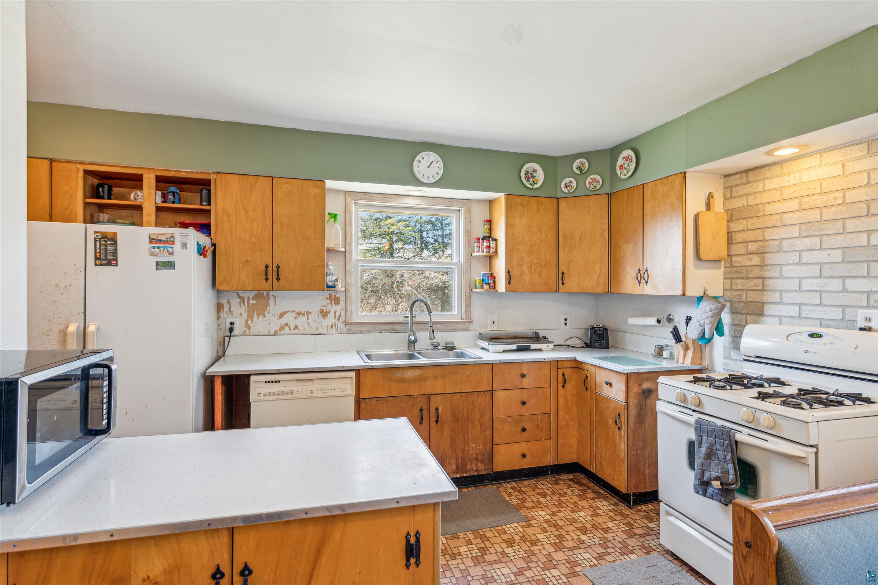 8920 School Road Port Wing, WI 54865 - Photo 12 of 27 Kitchen with a sink, light countertops, open shelves, and white appliances