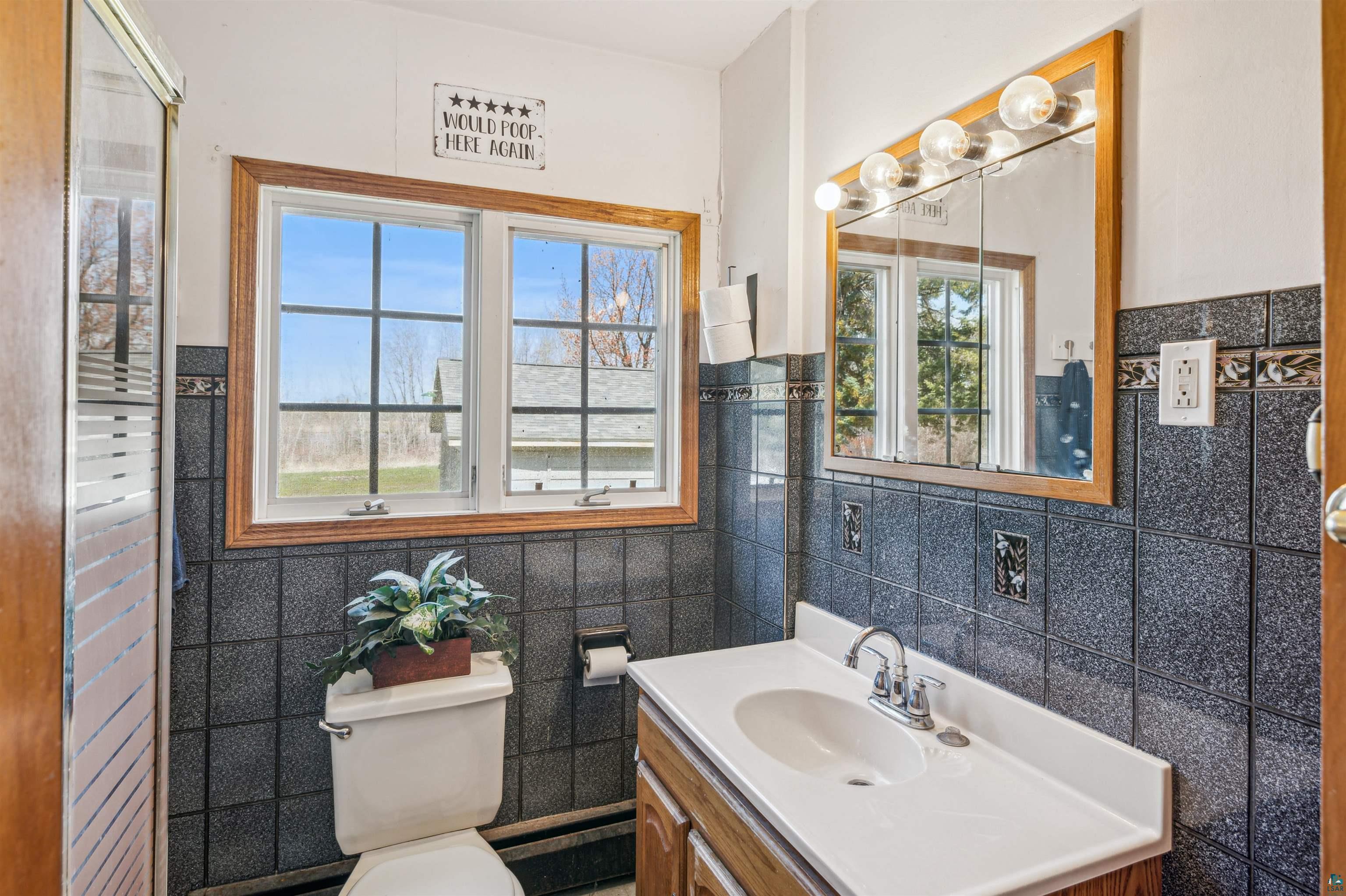 8920 School Road Port Wing, WI 54865 - Photo 16 of 27 Bathroom with tile walls, vanity, and toilet