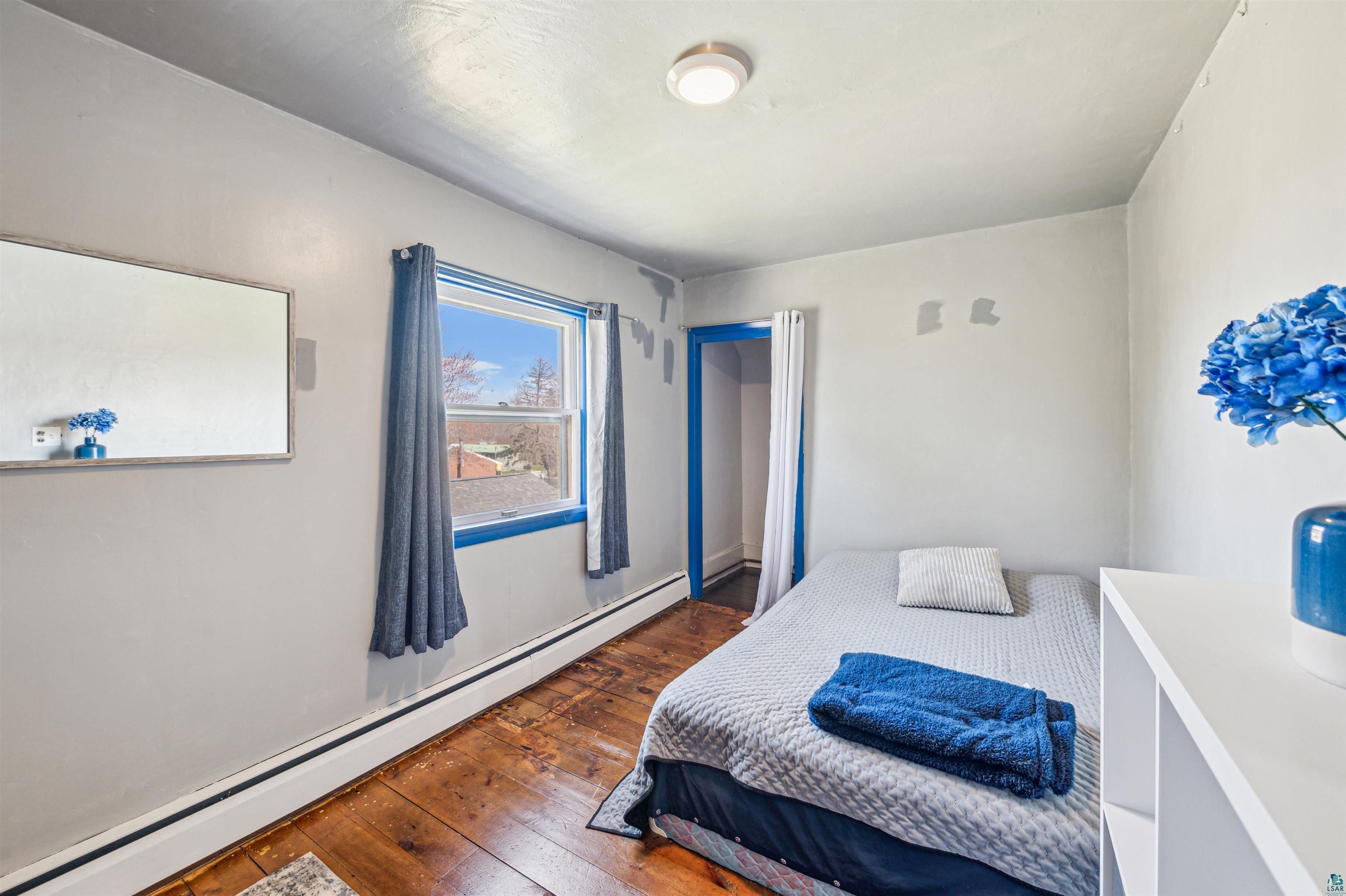 8920 School Road Port Wing, WI 54865 - Photo 20 of 27 Bedroom featuring wood-type flooring and baseboard heating