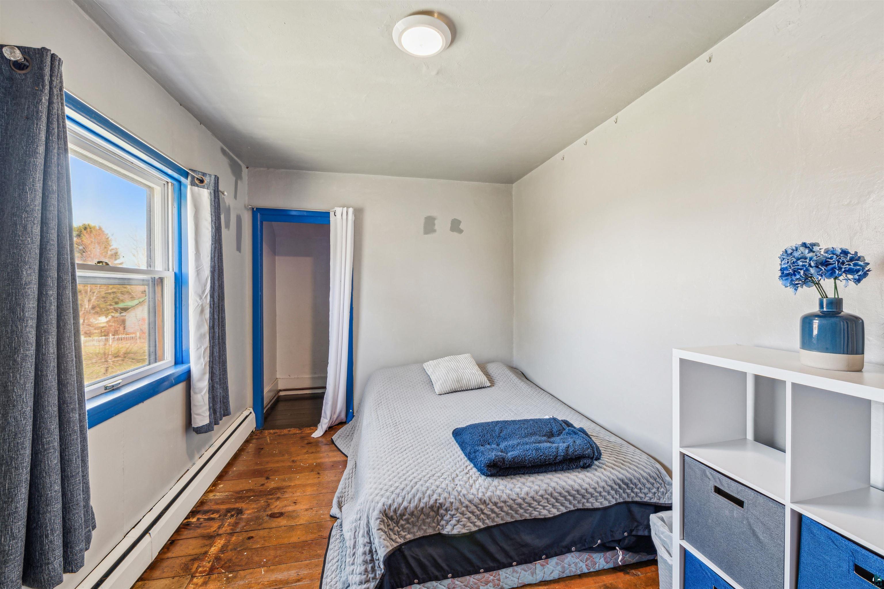 8920 School Road Port Wing, WI 54865 - Photo 21 of 27 Bedroom with a baseboard radiator and hardwood / wood-style floors