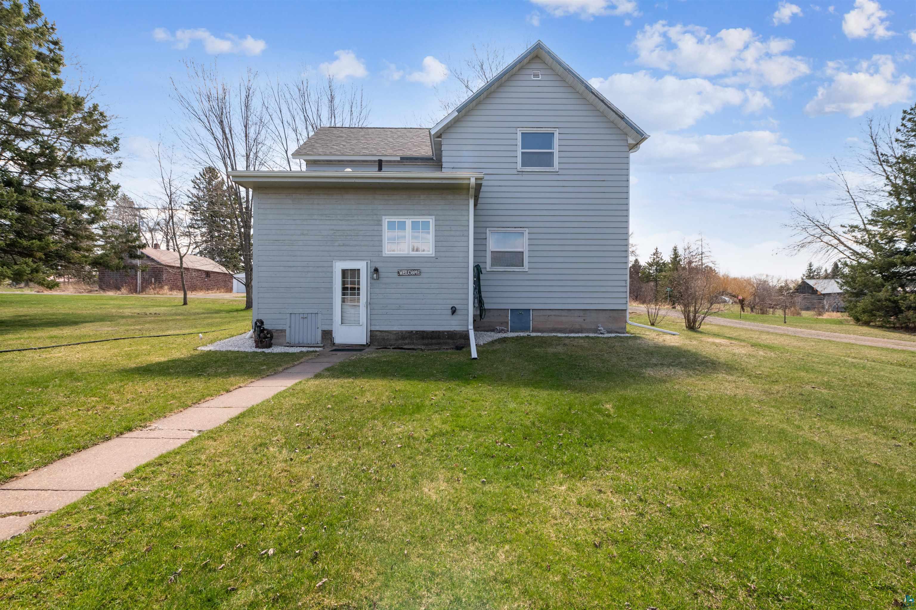 8920 School Road Port Wing, WI 54865 - Photo 24 of 27 Rear view of property with central air condition unit, a shingled roof, and a yard