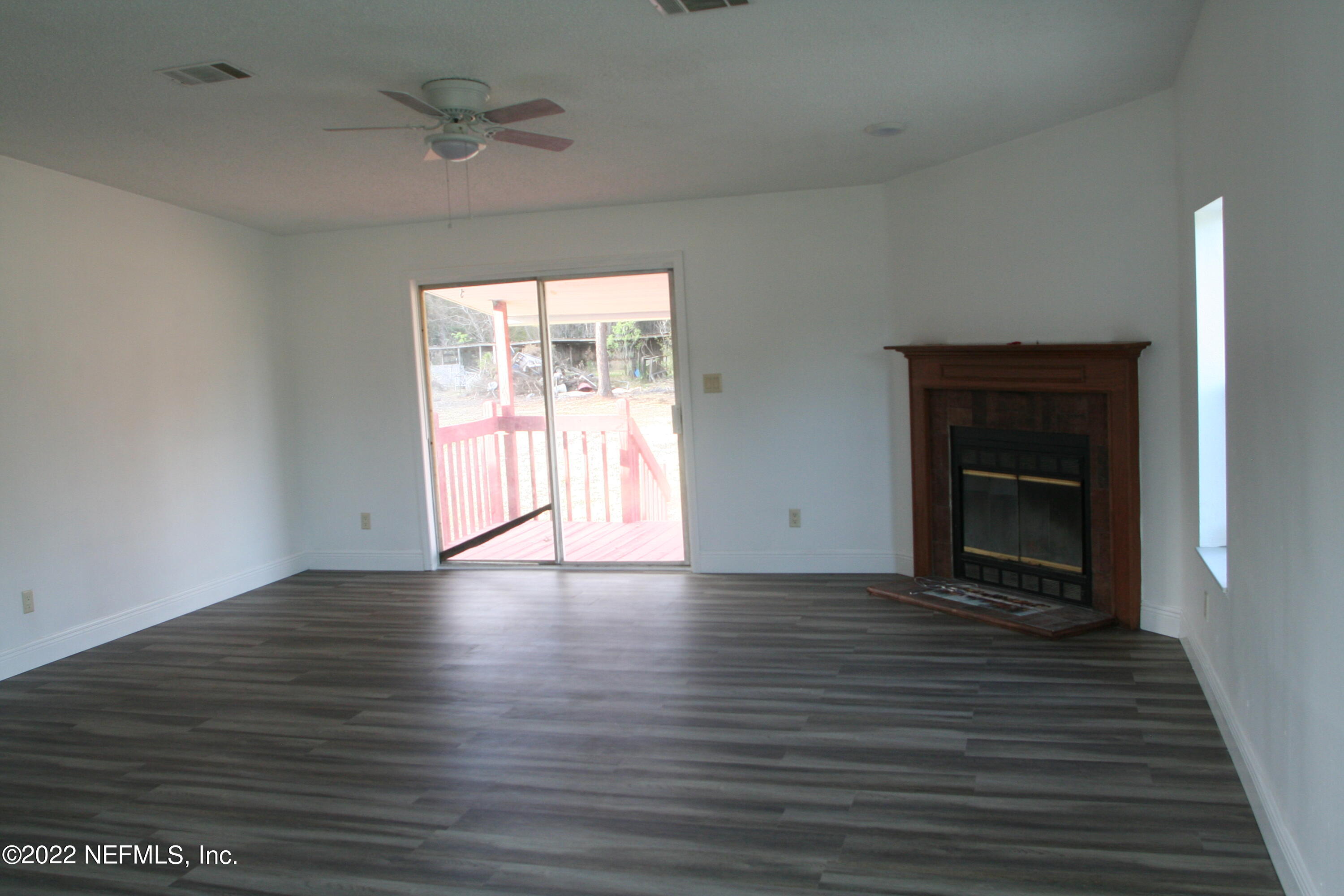 45657 Bismark Road Callahan, FL 32011 - Photo 12 of 21 wooden floor in an empty room with a fireplace