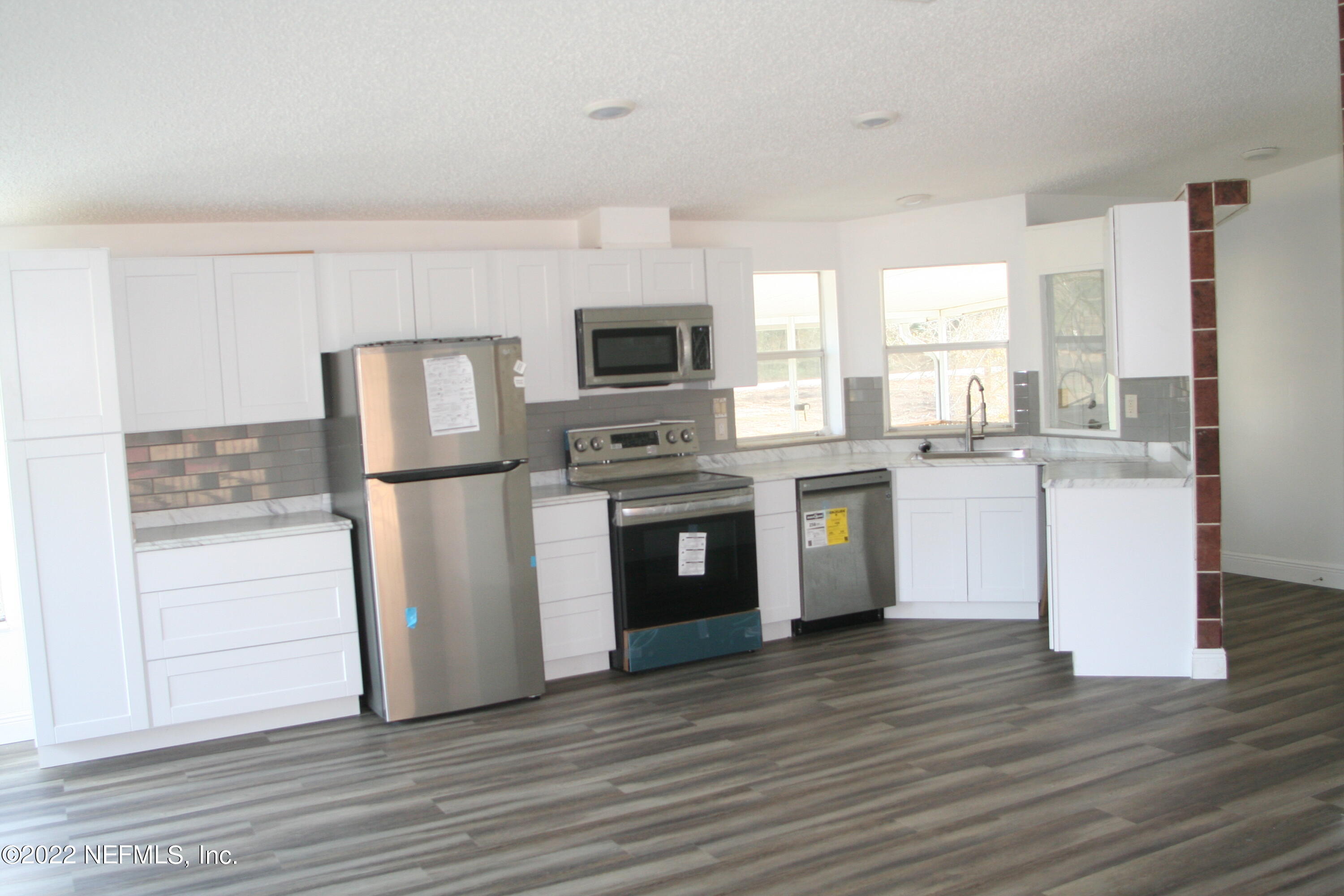 45657 Bismark Road Callahan, FL 32011 - Photo 13 of 21 a kitchen with a sink cabinets stainless steel appliances and wooden floor