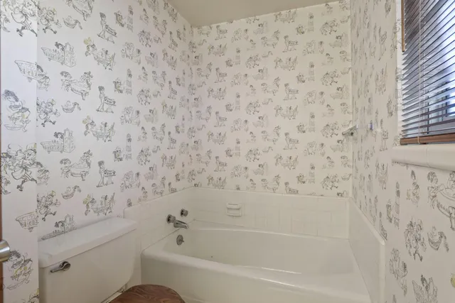 a view of an empty room with wooden floor and closet