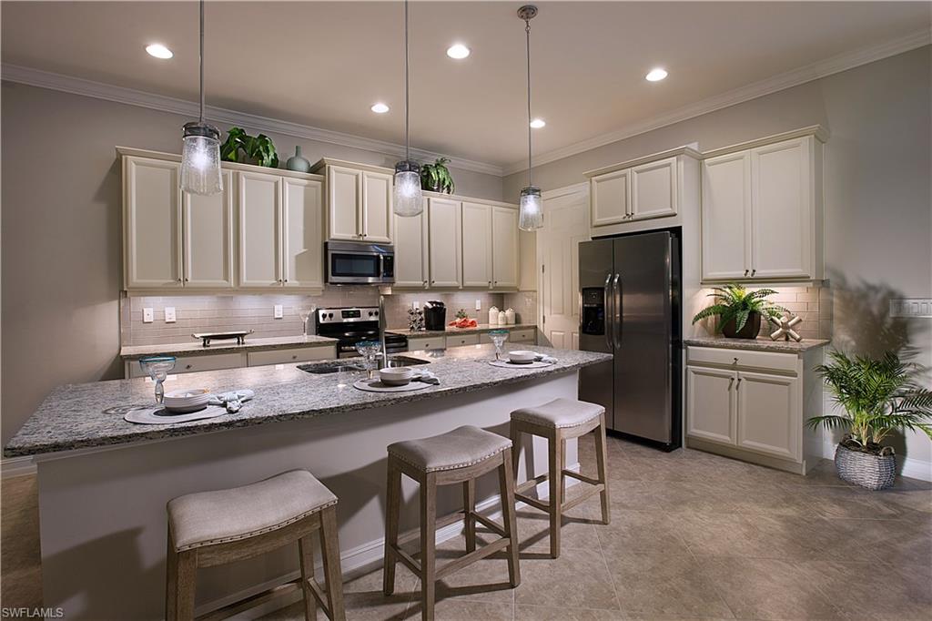 14731 Nautilus Place Naples, FL 34114 - Photo 17 of 22 a kitchen with a refrigerator and a dining table