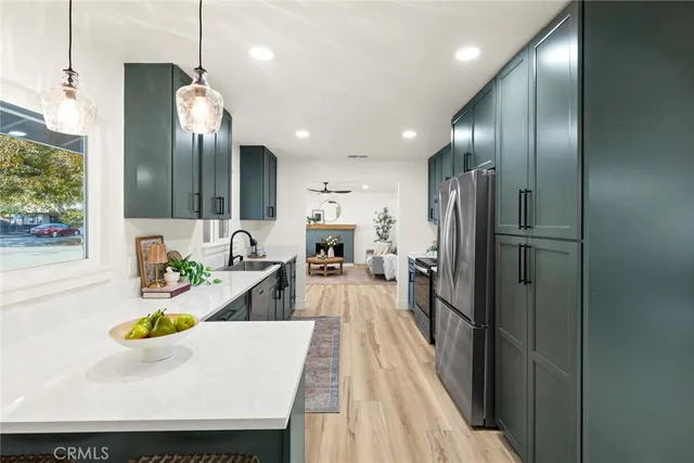 a kitchen with stainless steel appliances granite countertop a refrigerator and a sink