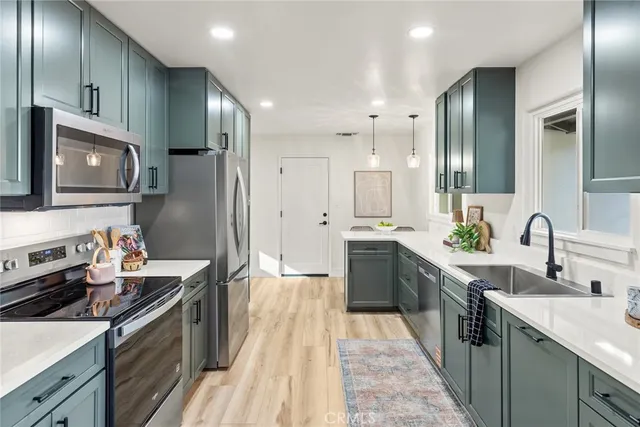a kitchen with stainless steel appliances a sink stove and refrigerator