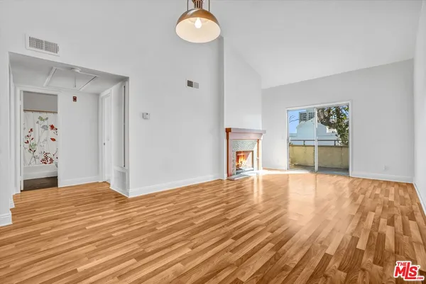 a view of empty room with wooden floor