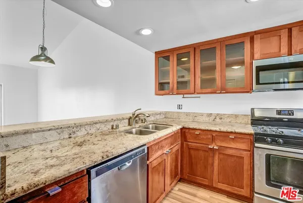 a kitchen with stainless steel appliances granite countertop a sink stove and cabinets