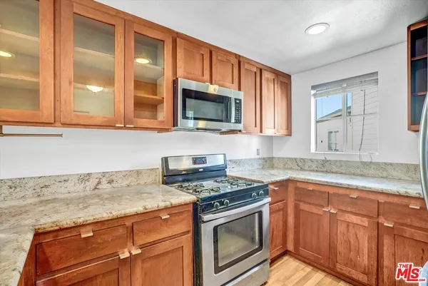 a kitchen with granite countertop cabinets stainless steel appliances and a sink