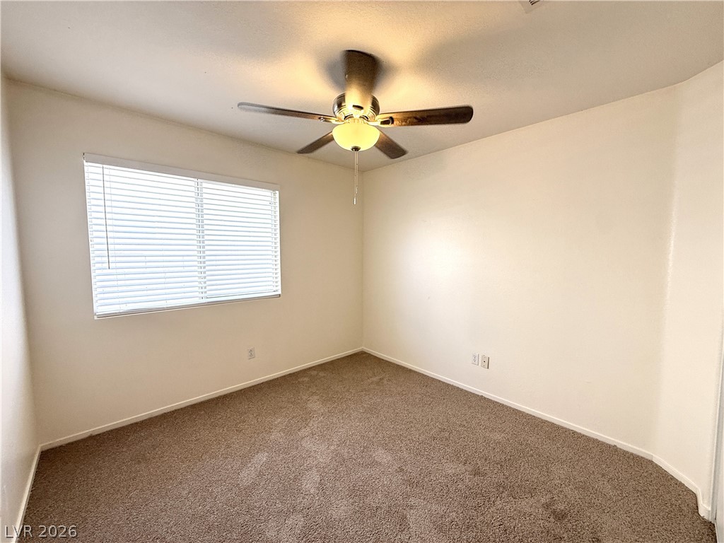 8870 Haviland Road Las Vegas, NV 89123 - Photo 11 of 22 Comfortable bedroom with soft carpeting and a ceiling fan, offering a tranquil retreat.