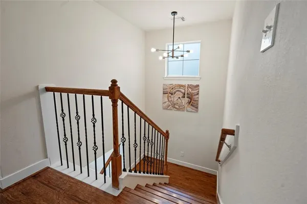 a view of a hallway with wooden floor and staircase