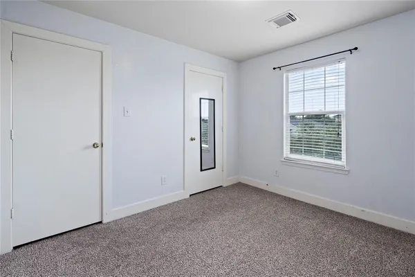 an empty room with windows and closet