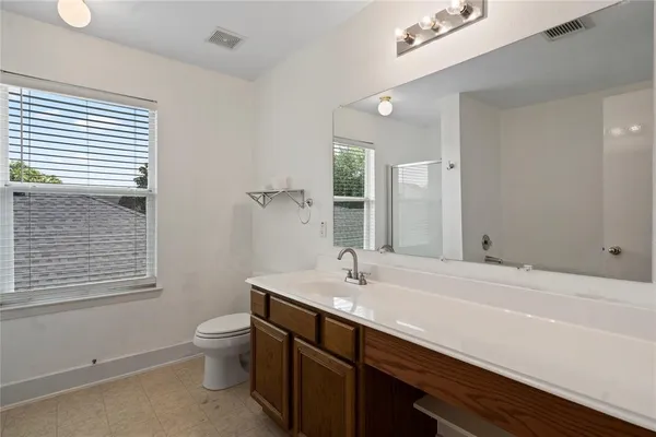 a bathroom with a sink mirror and toilet